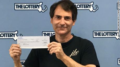 Stephen Toto displays his check after winning the Massachusetts lottery a second time.