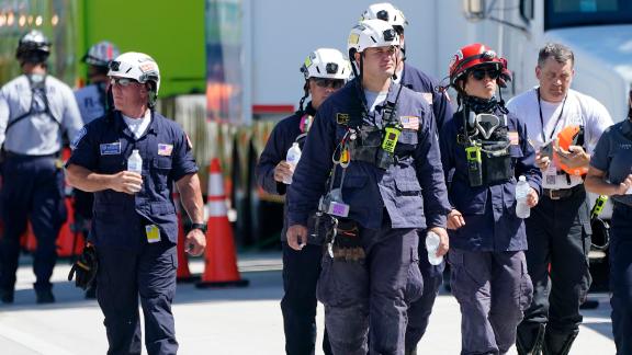 Members of the South Florida Urban Search and Rescue team walk near the Champlain Towers South condo building.