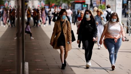 I pedoni indossano maschere mentre camminano lungo Oxford Street, nel centro di Londra, il 6 giugno.