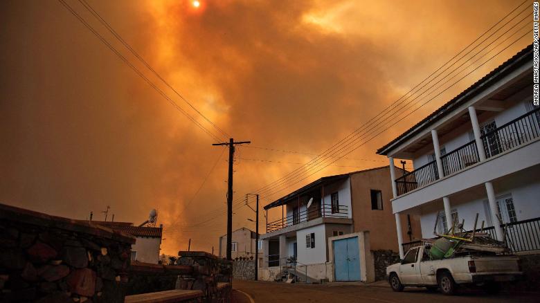 Heavy smoke covers the sky above the village of Ora in the southern slopes of the Troodos mountains, as a giant fire rages on the Mediterranean island of Cyprus, on July 3.