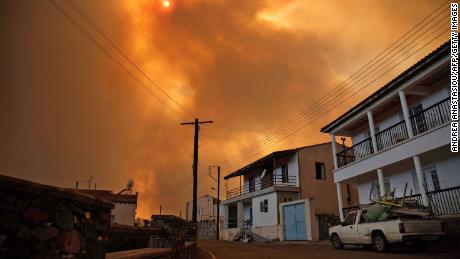 Heavy smoke covers the sky above the village of Ora in the southern slopes of the Troodos mountains, as a giant fire rages on the Mediterranean island of Cyprus, on July 3.