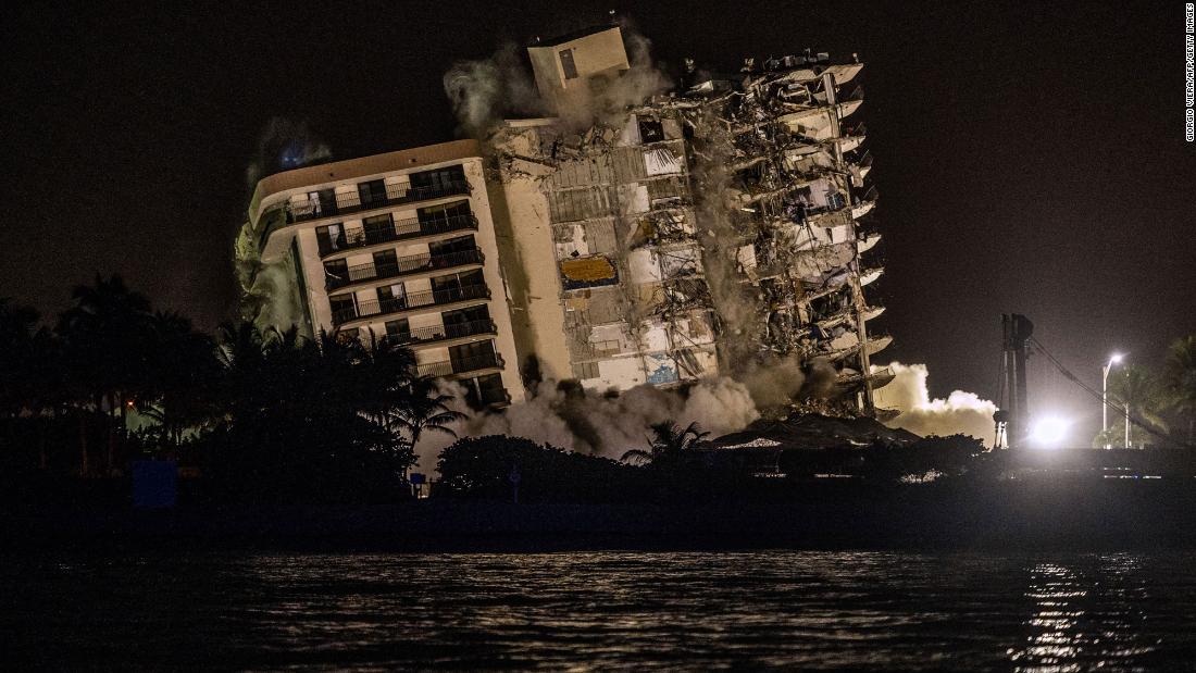 A controlled explosion brings down the unstable remains of the building on July 4.