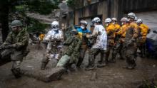 ATAMI, JAPAN - JULY 04: Rescue workers pull a rope to remove debris from a house damaged by a landslide on July 04, 2021 in Atami, Shizuoka, Japan. A rescue operation is underway after a landslide, caused by torrential rain, tore through the Japanese resort city of Atami on Saturday, killing two and leaving around twenty missing. (Photo by Yuichi Yamazaki/Getty Images)