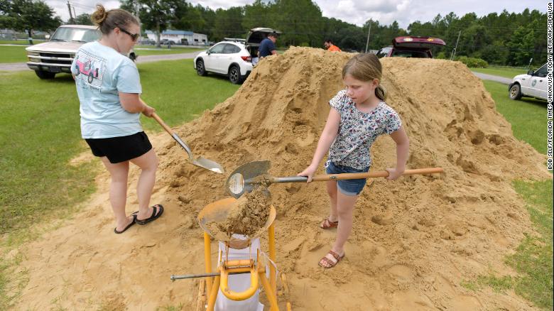 Emma Barlow, 9, works with her mother Brandi Barlow to fill sandbags Tuesday in Middleburg.