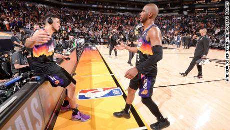 Booker high fives Paul after Game 1 against the Bucks.