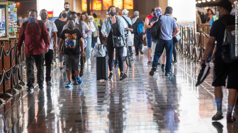 Wearing face masks, people walk last month through Union Station in Los Angeles. California is one of the 24 states seeing an uptick in Covid-19 cases. 