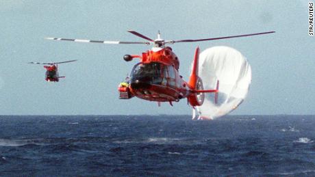 Coast Guard helicopters head back to the Barbers Point Naval Station after rescuing multi-millionaire adventurers Richard Branson and Steve Fossett and pilot Per Lindstrand after they were forced to abort their latest round-the-world bid due to bad weather December 25. The giant hot-air balloon, shown deflating in the Pacific Ocean off Hawaii, took off from Morocco December 18, travelled about 8,200 miles (13,120 kms) -- about half the distance of its intended odyssey.