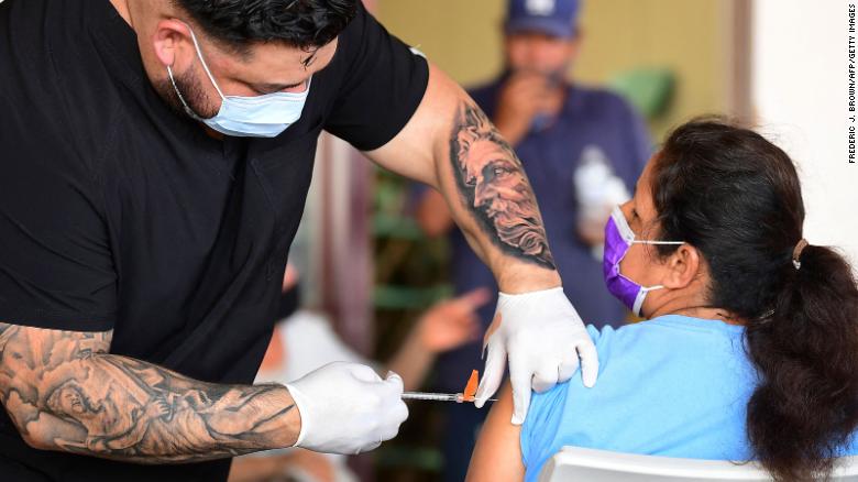 Respiratory therapist Robert Blas  administers the Covid-19 vaccine at a mobile clinic to residents in an East Los Angeles neighborhood which has a low vaccination rates, especially among the young, on July 9, 2021. Los Angeles County has been seeing exponential growth in Covid-19 cases in recent weeks. 