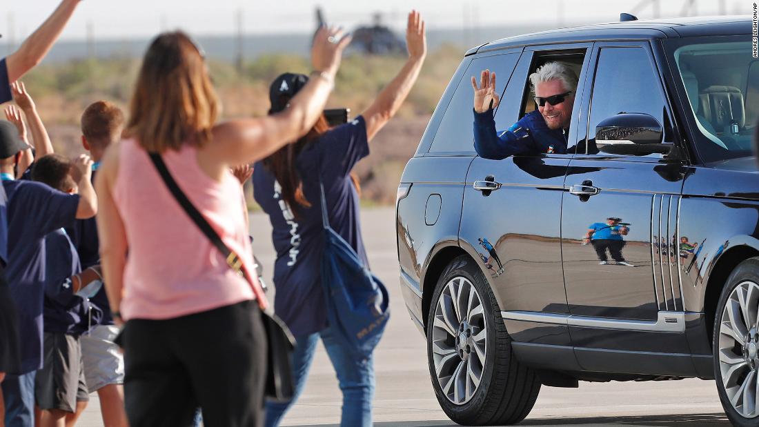 Richard Branson waves to schoolchildren while heading to board the space plane.