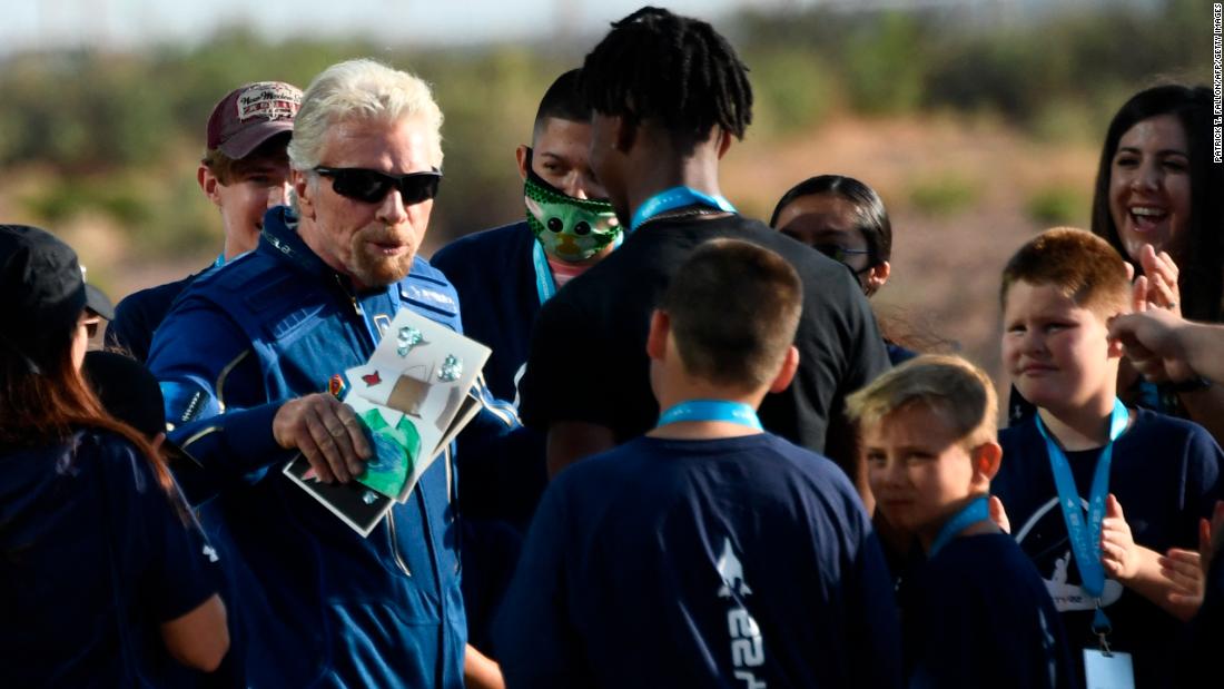Richard Branson receives some cards from schoolchildren as he walks out ahead of the flight.