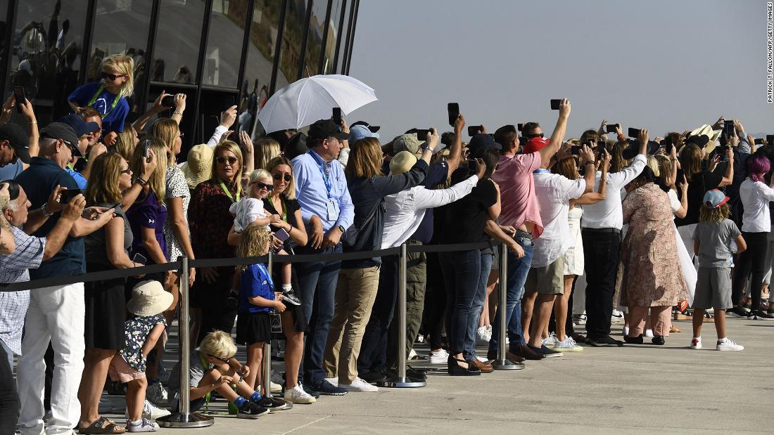 Spectators take photos and cheer as the Virgin Galactic space plane takes off.