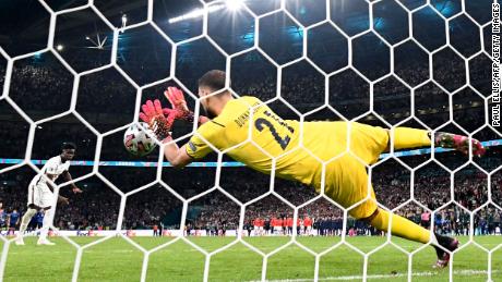 Italy&#39;s goalkeeper Gianluigi Donnarumma saves Bukayo Saka&#39;s penalty.