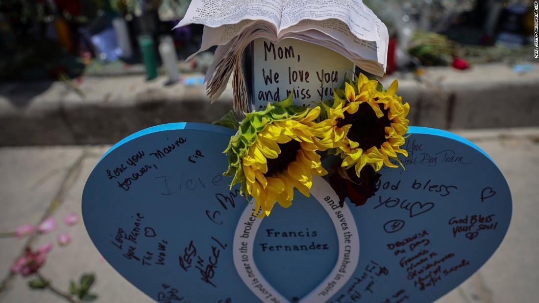 Wooden hearts with victims&#39; names have been put up at the memorial site near the building&#39;s remains.