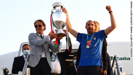 مدرب منتخب إيطاليا روبرتو مانشيني والقائد كيليني يحتفلان بكأس يورو 2020.