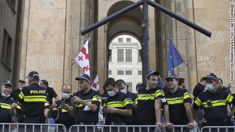 Police officers observe a rally outside the offices of the Georgian Parliament following the death of TV Pirveli journalist Alexander Lashkarava.