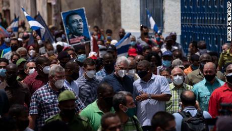 President Miguel Díaz-Canel (wearing a dark blue shirt with a mask) walks daily with supporters on Sunday after an anti-government protest in San Antonio de los Banos, Cuba.  