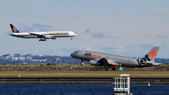 A Singapore Airlines flight lands next to a departing Jet Star aircraft at Sydney Airport on June 4, 2021.