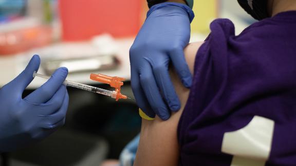 A healthcare worker administers a dose of a Pfizer-BioNTech Covid-19 vaccine to a child at a pediatrician's office in Bingham Farms, Michigan, U.S., on Wednesday, May 19, 2021. A Photographer: Emily Elconin/Bloomberg via Getty Images