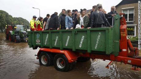 People ride on a trailer as the Dutch fire brigade evacuate people from their homes in South Limburg.