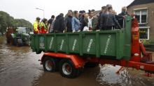 People ride on a trailer as the Dutch fire brigade evacuate people from their homes in South Limburg.