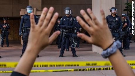 A demonstrator holds her hands up while she kneels in front of the police at the Anaheim City Hall last year in Anaheim, California, during a  protest over the death of George Floyd. 