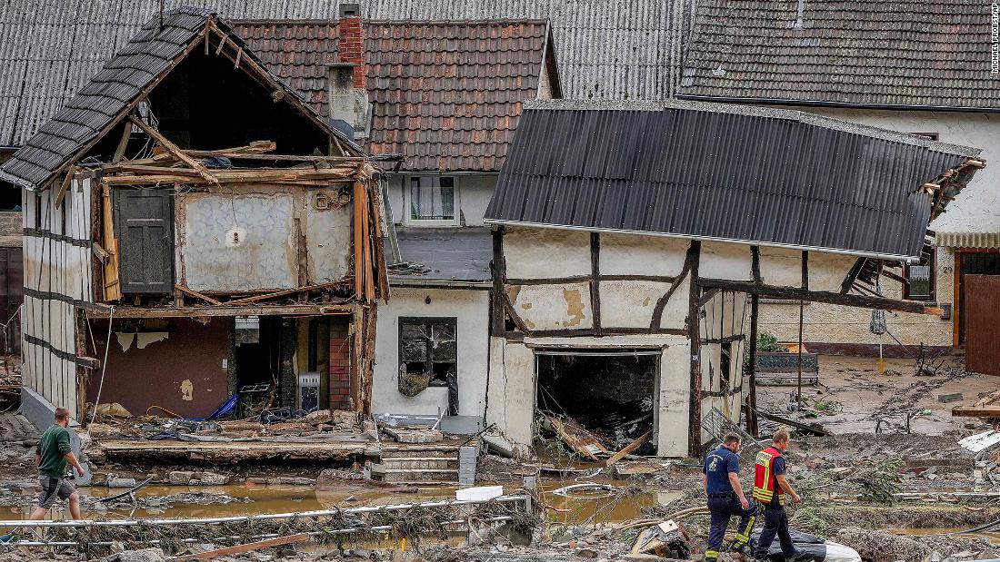 Men walk by damaged homes in Schuld, Germany.