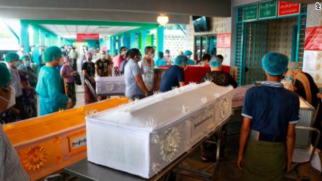 People wearing face masks wait while caskets with bodies are queued outside a crematorium at the Yay Way cemetery in Yangon, Myanmar, Wednesday July 14, 2021. The number of people dying in Myanmar&#39;s biggest city, Yangon, which is facing a coronavirus surge and a shortage of oxygen to treat patients, has been climbing so quickly that charity groups said Wednesday they are almost overwhelmed. (AP Photo)