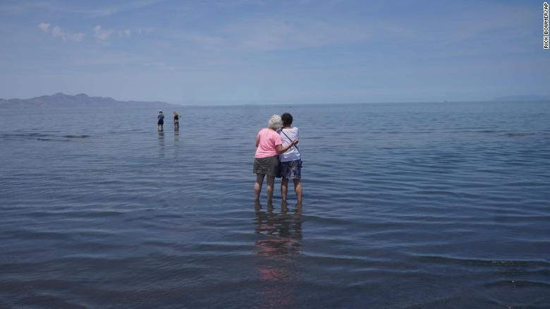 Visitors stand in June in the shallow waters of the Great Salt Lake.