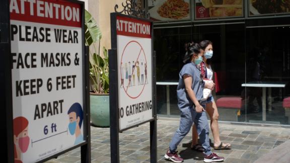 File - In this June 11, 2021 file photo customers wear face masks in an outdoor mall with closed business amid the COVID-19 pandemic in Los Angeles. Coronavirus cases have jumped 500% in Los Angeles County over the past month and health officials warned Tuesday, July 13, 2021, that the especially contagious delta variant of the disease continues to spread rapidly among California's unvaccinated population. (AP Photo/Damian Dovarganes,File)