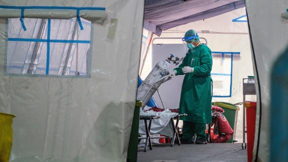 A medical personnel changes out an oxygen tank in a tent set up at a public hospital to handle the overflow of Covid-19 patients on June 24, 2021 in Jakarta, Indonesia. 
