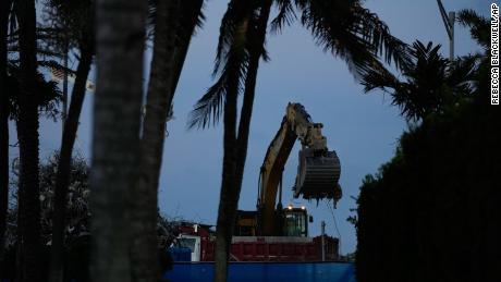 An excavator clears rubble at the site of the Champlain Towers South condo building collapse and demolition, Thursdayy.