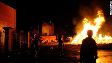A group of young loyalists watch a bonfire burn in the Belfast neighborhood of Tigers Bay on July 11, 2021.