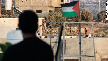 The Palestinian flag flies above the scene of clashes between Palestinians and Israeli soldiers in Beita.