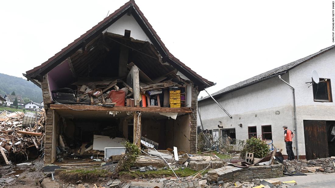 A man stands in front of a destroyed house in Schuld, Germany.