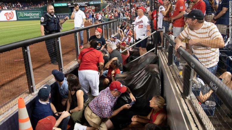 Fans take cover after gunshots were heard during the game between the Washington Nationals and the San Diego Padres at Nationals Park. 