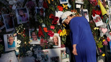 Valerie Flatto visits the memorial bearing photos of some of the victims of the partially collapsed 12-story Champlain Towers South condo building on July 15, 2021 in Surfside, Florida.