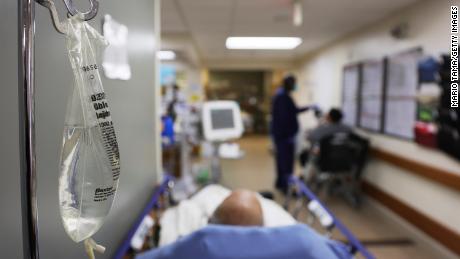 Patients rest in a hallway in an emergency room area.