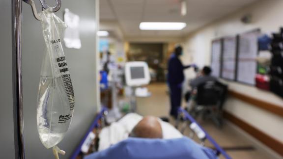 Patients rest in a hallway in an emergency room area.