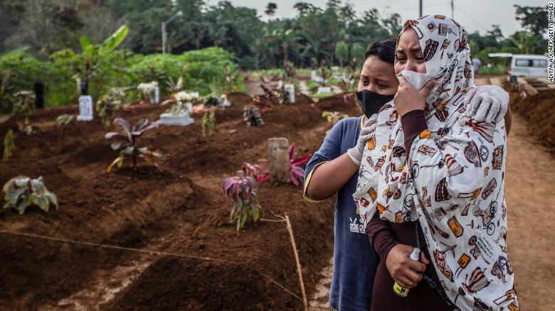 A mother mourns with her son during her mother&#39;s funeral at the Mulyaharja cemetery for Covid-19 coronavirus victims, in Bogor, West Java, on July 8, 2021.