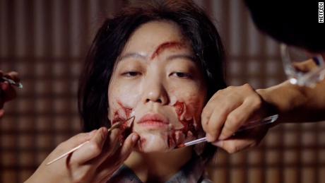 A special effects artist applies zombie makeup to actor for the South Korean Netflix series, Kingdom.