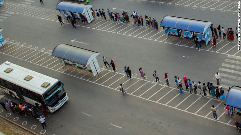 People wait for buses at a bus station in Kigali, capital city of Rwanda, on July 1.