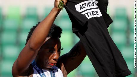 Gwen Berry holds up a shirt reading &quot;Activist Athlete&quot; as she celebrates finishing third in the Women&#39;s Hammer Throw final on day nine of the 2020 US Olympic Track &amp; Field Team Trials on June 26, 2021.