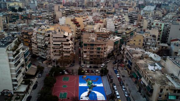 Artwork of Giannis Antetokounmpo on a basketball court in Athens.