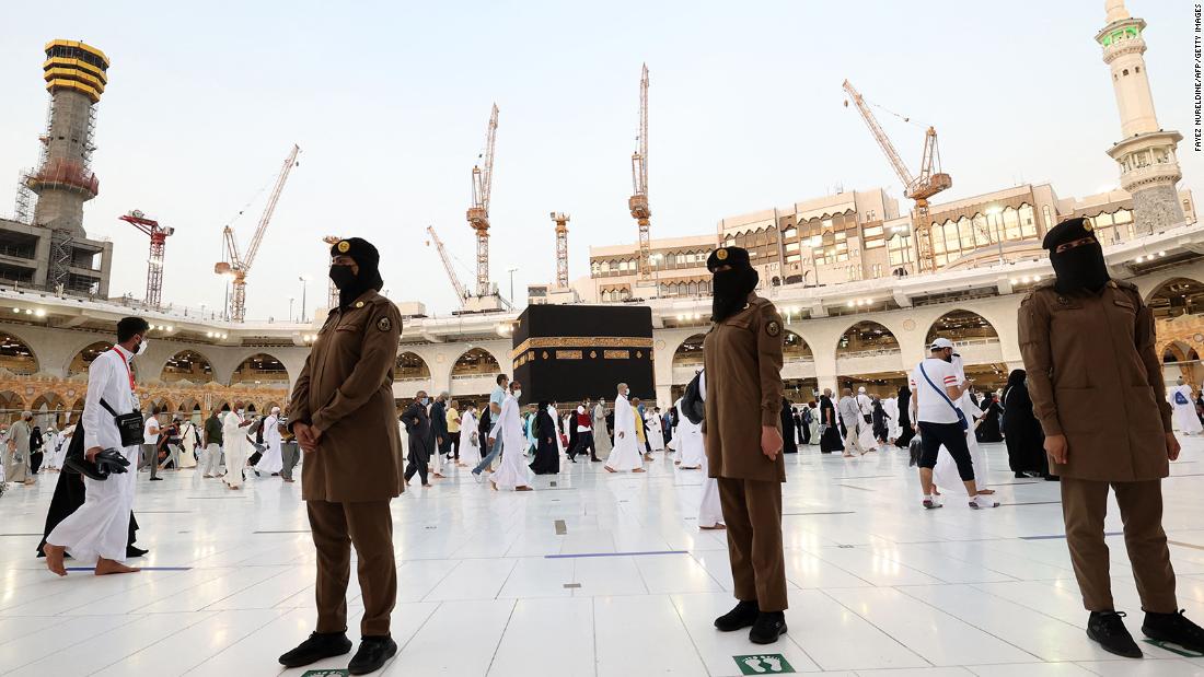 Saudi police officers stand guard as people walk around the Kaaba on Tuesday.