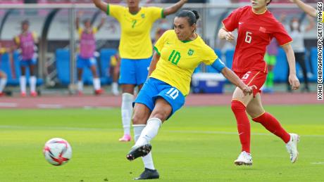 Brazil&#39;s midfielder Marta shoots to score the opening goal during the match against China.