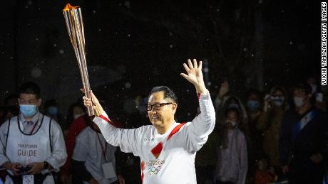 Toyoda runs with the Olympic torch during the Tokyo Olympic Games Torch Relay.