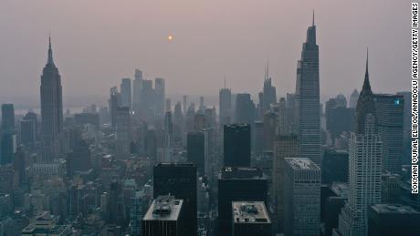 Wildfires burning out of control across the western US send haze across the continent to New York City, on July 20.