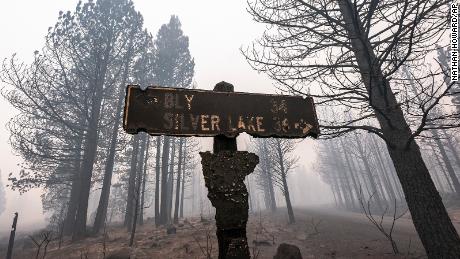 A sign damaged by the Bootleg Fire stands Thursday amid the haze near Paisley, Oregon.