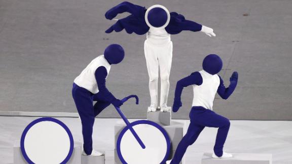 Live performers pose as the triathlon pictogram during the opening ceremony. There were 50 sports taking place this year in the Tokyo Olympics, and all of their <a href=