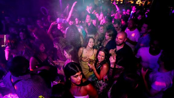 People drink on the dance floor shortly after the reopening, at The Piano Works in Farringdon, in London, Monday, July 19, 2021. Thousands of young people plan to dance the night away at 'Freedom Day' parties after midnight Sunday, when almost all coronavirus restrictions in England are to be scrapped. Nightclubs, which have been shuttered since March 2020, can finally reopen. (AP Photo/Alberto Pezzali)